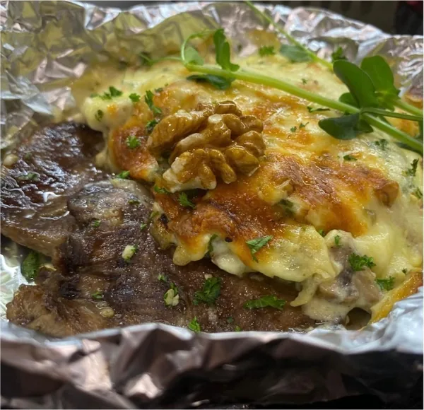 Язык, запечённый под соусом бешамель с грибами и грецким орехом
